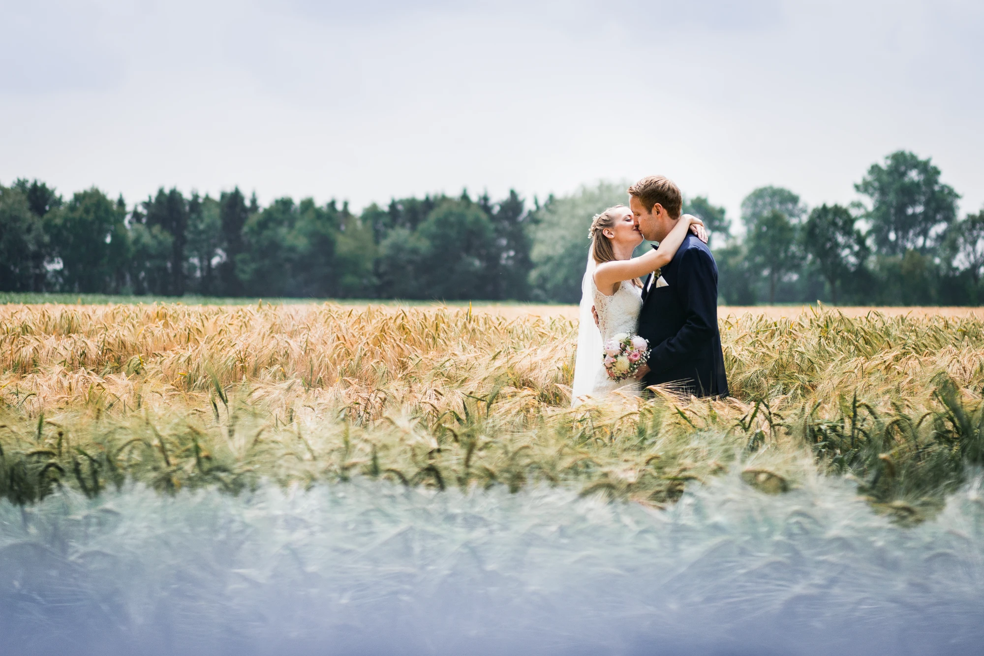 Brautpaar küsst sich in einem Kornfeld am Rande von Langenhorst - Hochzeitsfotograf Ochtrup