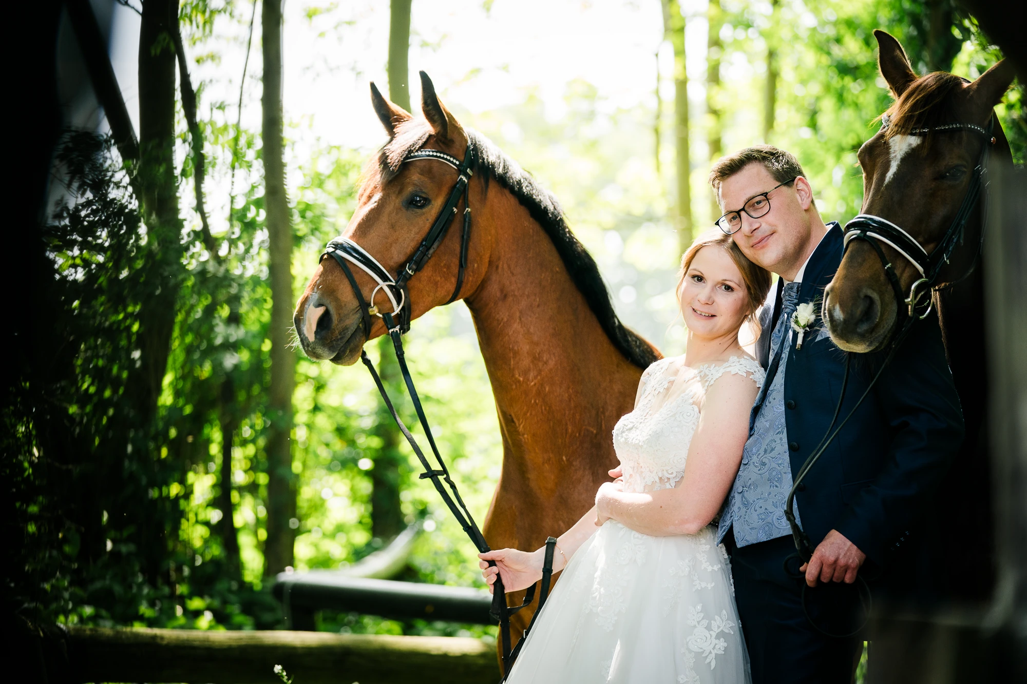Brautpaar mit den eigenen Pferden der Braut am Hochzeitstag im Wald – Hochzeitsfotograf Ochtrup