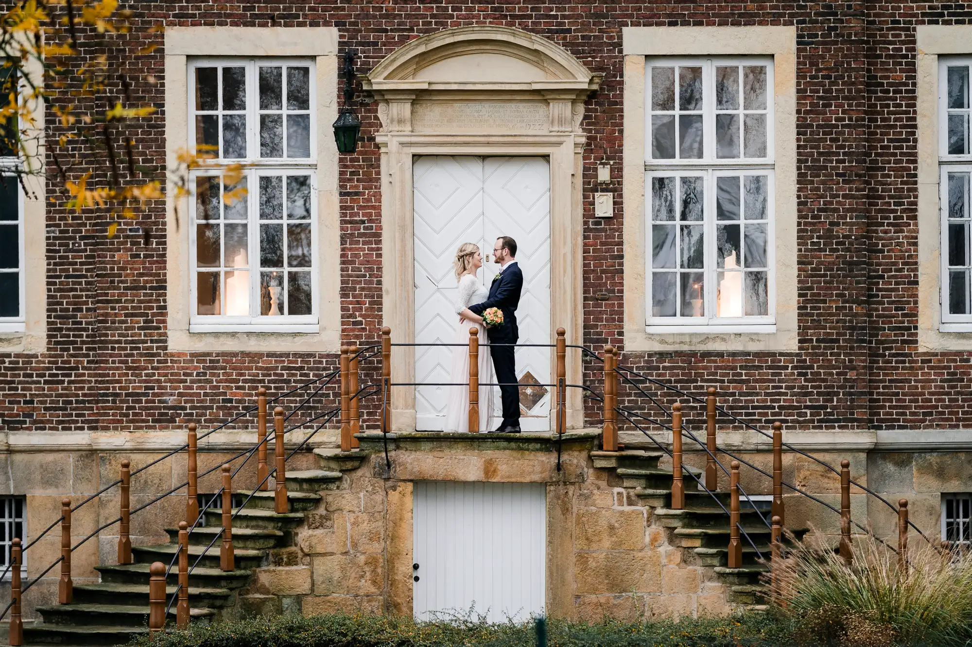 Brautpaar steht sich gegenüber auf der symmetrischen Treppe des Stift Langenhorst - Hochzeitsfotograf Ochtrup
