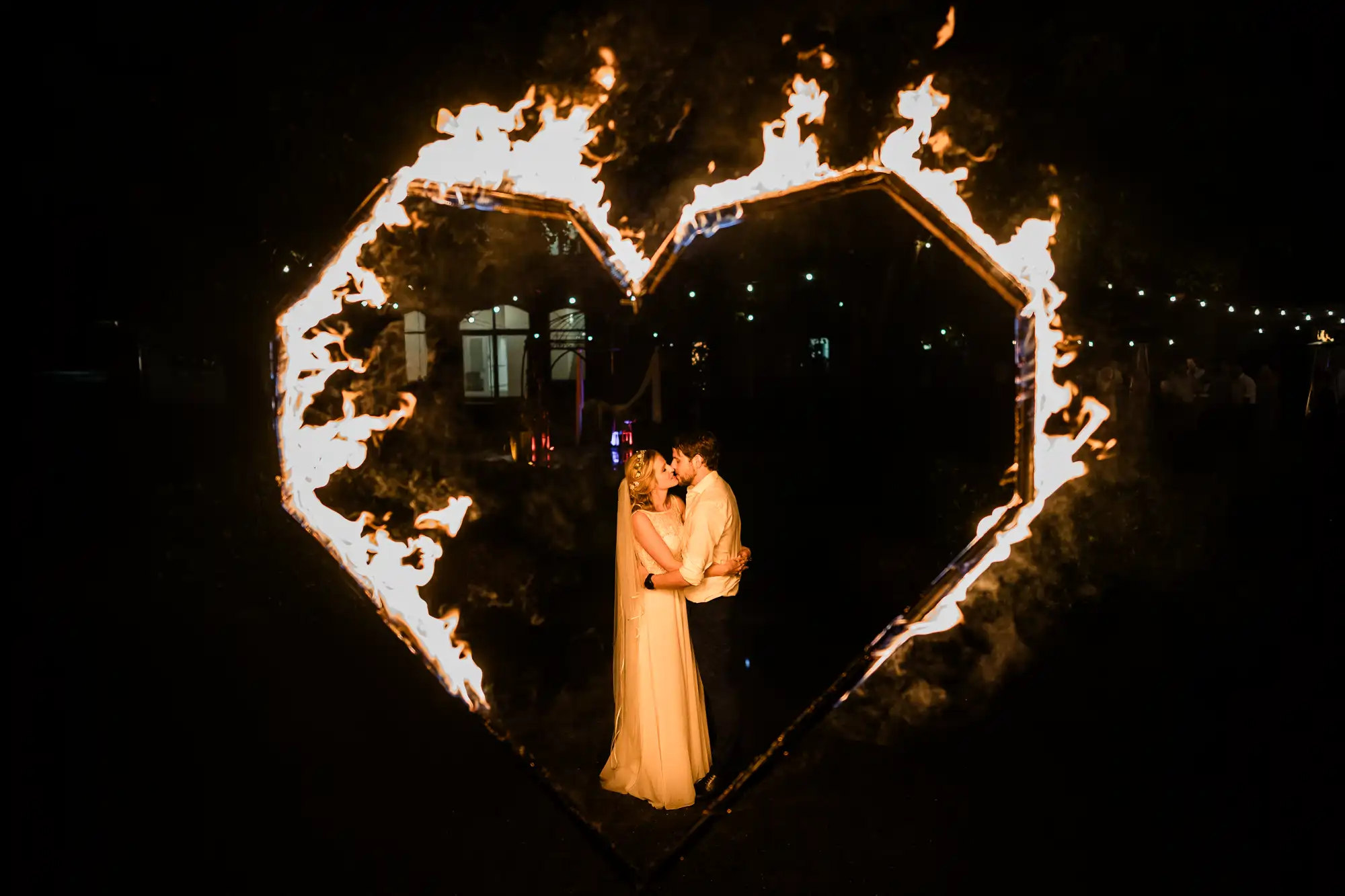 Brautpaar küsst sich in einem brennenden Feuerherz bei einer Hochzeit in Rheine
