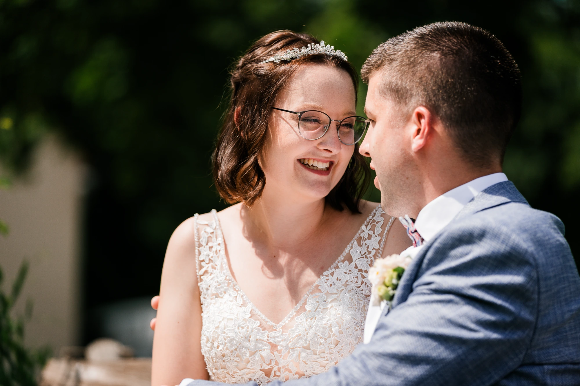 Braut lacht ihren Bräutigam beim Hochzeitsshooting an