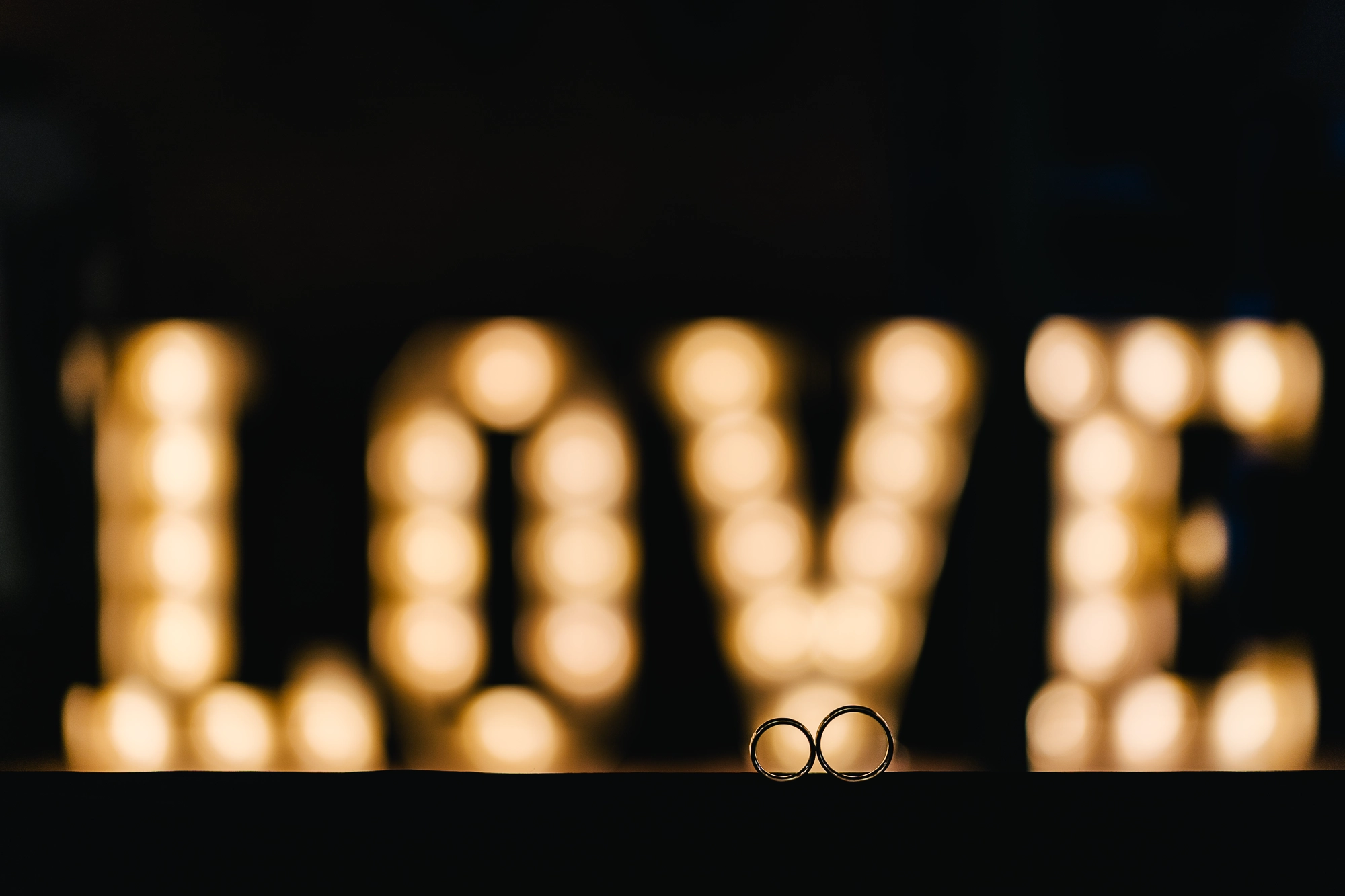 Zwei Eheringe vor einem leuchtenden "LOVE"-Schriftzug – Heiraten in Rheine